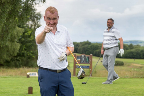 man playing golf pointing at the camera